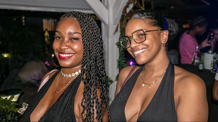Deux invitées en robes noires sourient